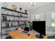 Well-lit office with modern shelving, desk, and shuttered window at 4287 Woodland Retreat Blvd, New Port Richey, FL 34655