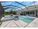 The screened-in pool area includes a hot tub, kitchen, and lounge area at 4287 Woodland Retreat Blvd, New Port Richey, FL 34655