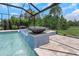 Screened-in pool with water feature and mosaic tiling adds luxury at 4287 Woodland Retreat Blvd, New Port Richey, FL 34655