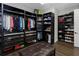 Custom walk-in closet with built-in shelving, drawers, and storage space with a brown ottoman at 4287 Woodland Retreat Blvd, New Port Richey, FL 34655