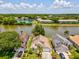 Aerial view of houses near lake surrounded by trees and lush greenery at 4716 Wolfram Ln, New Port Richey, FL 34653