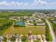 Aerial view of the community with lake and surrounding green space, featuring nearby shopping and dining at 4716 Wolfram Ln, New Port Richey, FL 34653