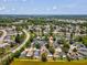 Aerial view of the community shows single Gathering homes on a lake with green space and nearby shopping at 4716 Wolfram Ln, New Port Richey, FL 34653