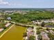 An aerial view of a lakefront home in a residential neighborhood with mature trees and green space at 4716 Wolfram Ln, New Port Richey, FL 34653