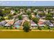 The aerial view of the community features single Gathering homes on a lake surrounded by trees and green space at 4716 Wolfram Ln, New Port Richey, FL 34653