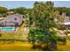 The lakefront backyard features large trees, green space, a pool and screen enclosure at 4716 Wolfram Ln, New Port Richey, FL 34653