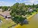 A lakefront backyard features mature trees, green space and patio with a hot tub at 4716 Wolfram Ln, New Port Richey, FL 34653