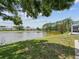 Lush backyard with pond view and mature trees, providing a serene outdoor space at 4716 Wolfram Ln, New Port Richey, FL 34653