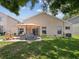 Backyard with patio seating, lush lawn and view of the lake at 4716 Wolfram Ln, New Port Richey, FL 34653