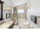 Bathtub and shower with a gray and white floral patterned shower curtain, and a gray tiled wall at 4716 Wolfram Ln, New Port Richey, FL 34653