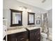 Bathroom with granite countertops, dual vanities, a decorative mirror, and a shower with a gray patterned shower curtain at 4716 Wolfram Ln, New Port Richey, FL 34653
