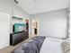Relaxing bedroom with neutral walls, a ceiling fan, and a dark dresser with a TV, and a view to the bathroom at 4716 Wolfram Ln, New Port Richey, FL 34653