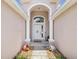 Welcoming front entryway with an arched doorway, decorative planters, and manicured landscaping at 4716 Wolfram Ln, New Port Richey, FL 34653