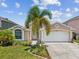 Inviting single-story home with a two-car garage, lush landscaping, and a welcoming facade at 4716 Wolfram Ln, New Port Richey, FL 34653