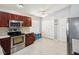 Well-equipped kitchen with stainless steel appliances, wood cabinets, and tile flooring for a functional cooking space at 4716 Wolfram Ln, New Port Richey, FL 34653