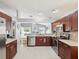 Modern kitchen features stainless steel appliances, wooden cabinets, and a view into the living area at 4716 Wolfram Ln, New Port Richey, FL 34653