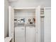 Bright laundry closet featuring a full-size white washer and dryer, plus wire shelving for easy organization at 4716 Wolfram Ln, New Port Richey, FL 34653
