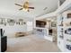 Open-concept living room that features a ceiling fan and a half wall that overlooks the kitchen and laundry area at 4716 Wolfram Ln, New Port Richey, FL 34653