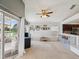 Bright living room with neutral carpet, ceiling fan, and sliding glass doors leading to a screened patio with a lake view at 4716 Wolfram Ln, New Port Richey, FL 34653