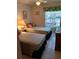 Sunlit bedroom featuring twin beds, bright window, and tiled floors at 6050 Chesham Dr # 3, New Port Richey, FL 34653