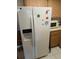 Side-by-side refrigerator in kitchen, with laminate wood cabinets and tiled flooring at 6050 Chesham Dr # 3, New Port Richey, FL 34653