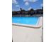 Outdoor pool with clear blue water and lounge chairs behind a black fence at 6050 Chesham Dr # 3, New Port Richey, FL 34653