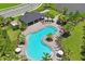 Aerial view of the community pool with lounge chairs, palm trees, a shaded area, and well-maintained landscaping at 6240 Fairmont Ln, Palmetto, FL 34221