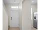 Entryway view with a front door, leading to the stairs and kitchen, with neutral tile flooring at 6240 Fairmont Ln, Palmetto, FL 34221