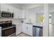 Well-lit kitchen with stainless steel appliances, white cabinetry, counter space, and an open layout at 6240 Fairmont Ln, Palmetto, FL 34221