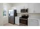 Modern kitchen with stainless steel appliances, white cabinets, countertops and a window offering natural light at 6240 Fairmont Ln, Palmetto, FL 34221