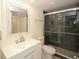 Modern bathroom featuring a sleek glass enclosed shower with black and gray tile at 6806 Beach Blvd, Hudson, FL 34667