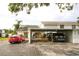 A view of a home's exterior featuring a convenient carport and landscaped surroundings at 6806 Beach Blvd, Hudson, FL 34667
