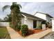 Charming home exterior featuring a white facade, manicured landscaping, and a welcoming sidewalk at 6806 Beach Blvd, Hudson, FL 34667