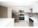 Modern kitchen featuring stainless steel appliances, white cabinetry, and gray backsplash at 6806 Beach Blvd, Hudson, FL 34667