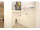 Well-lit laundry room features modern water heater, washer hookups and wire shelving storage at 6806 Beach Blvd, Hudson, FL 34667
