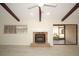 Bright living room featuring a brick fireplace, wood beams, and sliding glass doors at 6806 Beach Blvd, Hudson, FL 34667