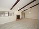 Open living room with brick fireplace, wood beams, and ample natural light at 6806 Beach Blvd, Hudson, FL 34667