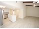 Open floor plan connecting kitchen with white cabinets, beams, and vaulted ceiling at 6806 Beach Blvd, Hudson, FL 34667