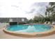 Community pool with clear water, a nearby building, surrounding deck and lounge chairs at 6806 Beach Blvd, Hudson, FL 34667