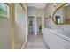 Bathroom featuring a glass-enclosed shower, vanity, neutral tile flooring, patterned wallpaper and a decorative mirror at 7275 Crystal Spring Run, Weeki Wachee, FL 34607