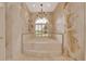 Luxurious bathroom featuring a deep soaking tub, rope trim, and a chandelier at 7275 Crystal Spring Run, Weeki Wachee, FL 34607