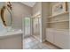 Bright bathroom featuring a glass-enclosed shower, vanity, patterned wallpaper and access to the outside at 7275 Crystal Spring Run, Weeki Wachee, FL 34607