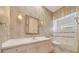 Elegant bathroom featuring a vanity with decorative mirror and sconces, plus a tub and patterned wallpaper at 7275 Crystal Spring Run, Weeki Wachee, FL 34607