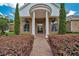Charming front porch with brick walkway, stately columns, and manicured landscaping at 7275 Crystal Spring Run, Weeki Wachee, FL 34607