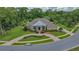 Aerial view of a brick home with circular driveway, well-maintained lawn, and lush surrounding trees at 7275 Crystal Spring Run, Weeki Wachee, FL 34607