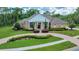 Beautiful brick home featuring a manicured lawn, elegant landscaping, and a circular driveway at 7275 Crystal Spring Run, Weeki Wachee, FL 34607