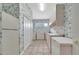 Functional laundry room with floral wallpaper, ample cabinet space, a sink and tile flooring at 7275 Crystal Spring Run, Weeki Wachee, FL 34607