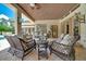 Spacious covered patio with comfortable seating, offering a relaxing view of the pool and garden at 7275 Crystal Spring Run, Weeki Wachee, FL 34607