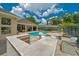 Outdoor bar area by the pool, complemented by cozy seating and a lush landscape at 7275 Crystal Spring Run, Weeki Wachee, FL 34607