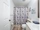 Well-lit bathroom showcasing a sink, toilet, and a shower/tub with a fun ocean-themed curtain and seaside decor at 7518 Mediterranean Ct, Hudson, FL 34667